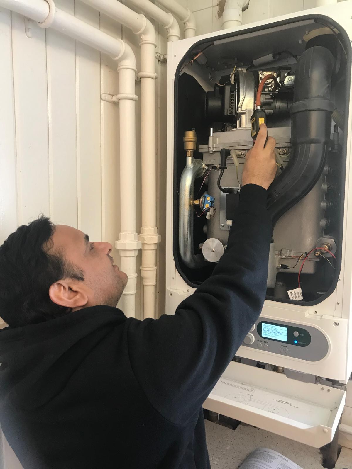 Engineer checking internal boiler components during service